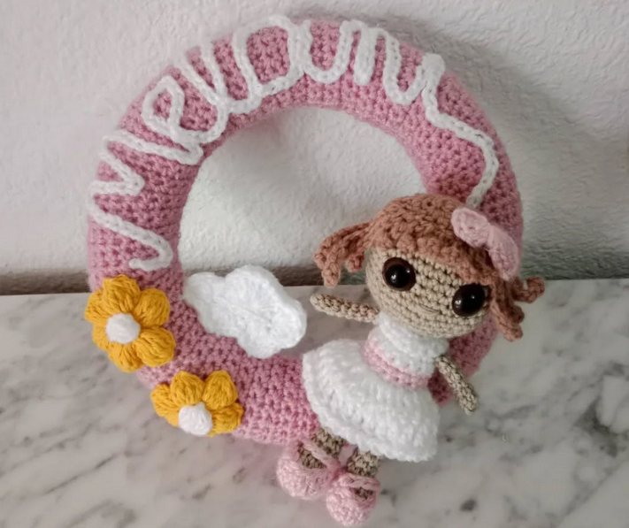 Handmade crochet pink wreath with doll and "Meyoun" text from abrasmin.com